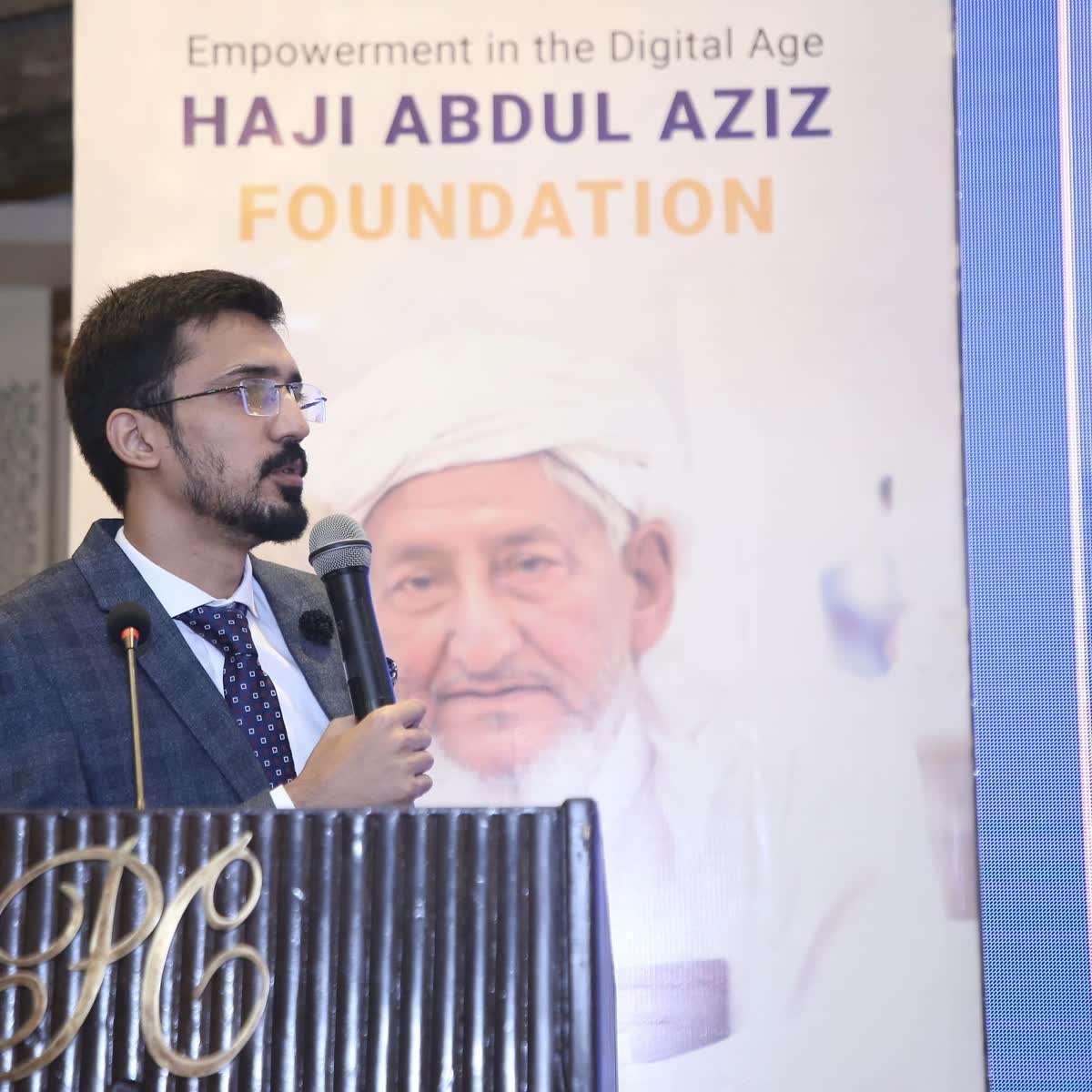 Umair Majeed speaking at the TechLift graduation ceremony, in front of the Haji Abdul Aziz Foundation banner, June 2023